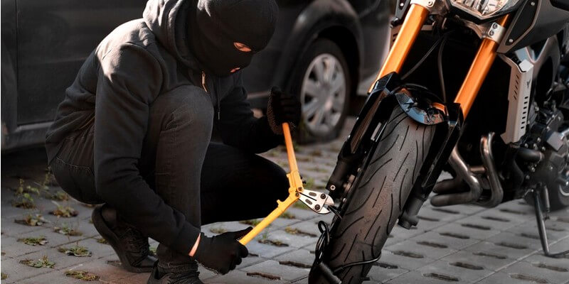 Ladro che taglia la catena di una motocicletta