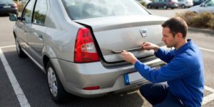 Homme ouvrant un coffre de voiture bloqué